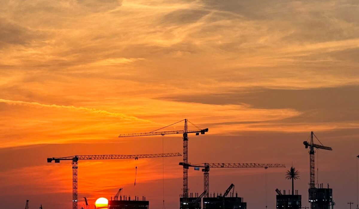 Escrow accounts law in Dubai construction cranes at sunset for off-plan buyer protection