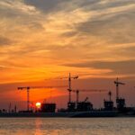 Escrow accounts law in Dubai construction cranes at sunset for off-plan buyer protection